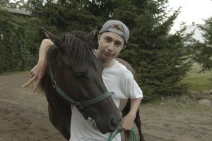 Młody chłopak obejmuje konia