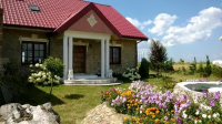 Dom, wejście z kolumnami, po prawej kwiaty