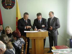 Trzej mężczyźni podpisują dokumenty